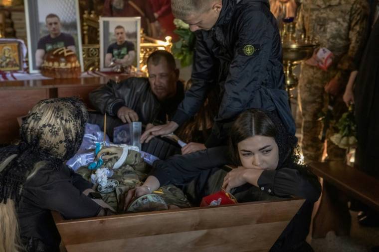Anastasia aux côtés du cercueil de son petit ami, le soldat ukrainien Nazary Gryntsevych tué au combat, lors de ses funérailles le 10 mai 2024 ( AFP / Roman PILIPEY )