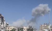 À Gaza, une volute de fumée s'élève au-dessus de bâtiments détruits