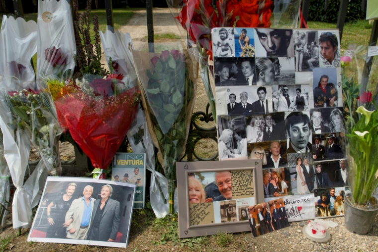 Des fleurs et des photos d'Alain Delon déposées par des admirateurs à l'entrée de la propriété de l'acteur décédé, le 19 août 2024 à Douchy, dans le Loiret  ( AFP / GUILLAUME SOUVANT )