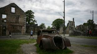 L'épave rouillée d'une vieille voiture dans les ruines du village d'Oradour-sur-Glane, le 13 mai 2024 en Haute-Vienne ( AFP / Philippe LOPEZ )