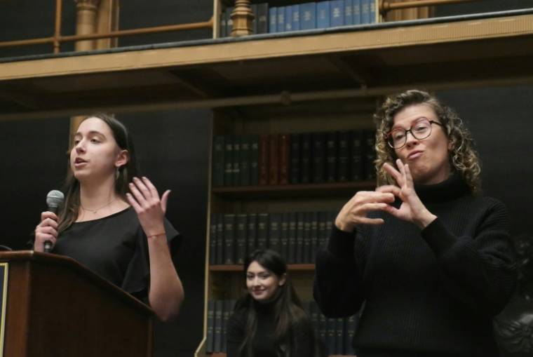 Uné étudiante (G) et une interprète (D) en langue des signes américaine lors d'un débat entre étudiants à Washington, aux Etats-Unis, le 11 avril 2024 ( AFP / Amel SEMMACHE )