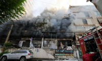 Des secouristes luttent contre les flammes à l'intérieur d'un bâtiment incendié par une frappe israélienne qui a visé la banlieue sud de Beyrouth, le 6 octobre 2024 ( AFP / ANWAR AMRO )