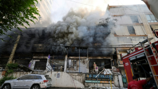 Des secouristes luttent contre les flammes à l'intérieur d'un bâtiment incendié par une frappe israélienne qui a visé la banlieue sud de Beyrouth, le 6 octobre 2024 ( AFP / ANWAR AMRO )