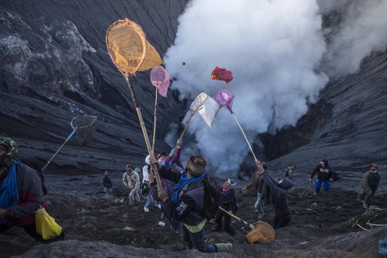 Des milliers de personnes font l'ascension du mont Bromo le 26 juin 2021, un volcan actif de l'est de l'île indonésienne de Java, pour une cérémonie religieuse durant laquelle des offrandes rituelles sont jetées dans le cratère fumant.  ( AFP / JUNI KRISWANTO )