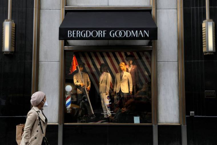 Une personne portant un masque passe devant Bergdorf Goodman sur la Cinquième Avenue, alors que les détaillants signalent une baisse des ventes liée à l'épidémie de coronavirus à Manhattan, New York City.