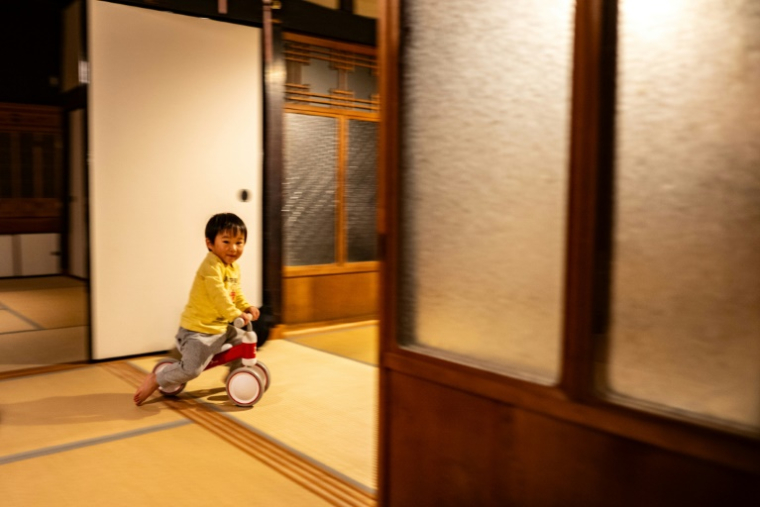 Kuranosuke Kato, fils de Rie Kato et Toshiki Kato, sur son tricycle dans leur maison du village d'Ichinono, le 20 octobre 2024 au Japon ( AFP / Philip FONG )