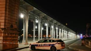 Une voiture de police est garée dans le périmètre de sécurité mis en place après une attaque au couteau et au marteau, le 2 décembre 2023 à Paris ( AFP / Dimitar DILKOFF )