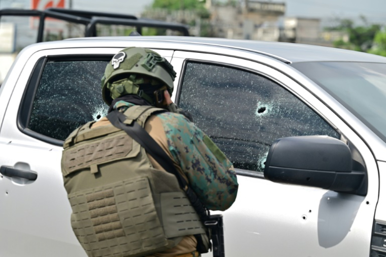 Un militaire observe les impacts de balles sur la camionnette dans laquelle un colonel des forces armées équatoriennes a été abattu à Guayaquil, Équateur, le 14 février 2025 ( AFP / MARCOS PIN )