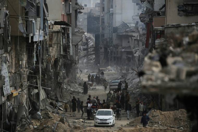 Des Palestiniens au milieu d'immeubles détruits par des frappes israéliennes à Khan Younès, dans le sud de la bande de Gaza, le 8 avril 2024 ( AFP / - )