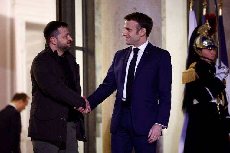 Le président français Emmanuel Macron serre la main du président ukrainien Volodimir Zelensky alors qu'il arrive à une réunion pour signer un accord de sécurité bilatéral au palais de l'Élysée à Paris