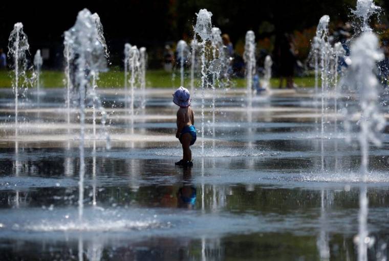 Un enfant se rafraichit dans une fontaine publique à Nice