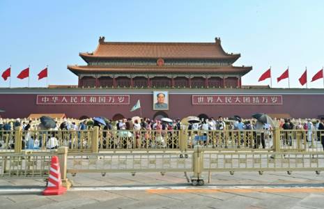 Des personnes marchent devant le portrait de Mao Tsé-toung sur la place Tiananmen, le 4 juin 2024 à Pékin ( AFP / Adek BERRY )