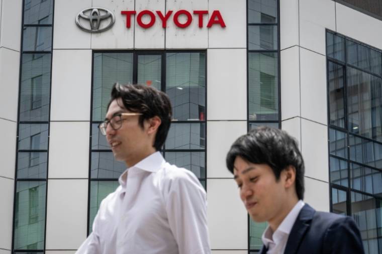 Des piétons passent devant un concessionnaire automobile du constructeur japonais Toyota à Tokyo, le 8 mai 2024 ( AFP / Yuichi YAMAZAKI )