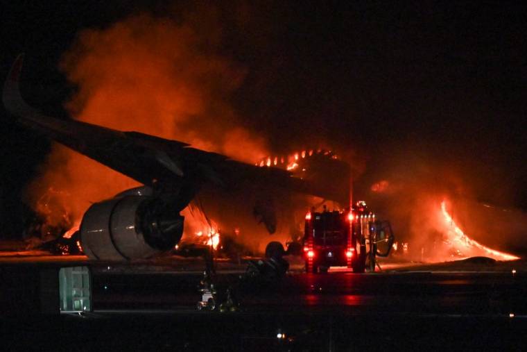 Un avion de ligne Japan Airlines (JAL) en feu sur le tarmac de l'aéroport international de Tokyo à Haneda ce mardi 2 janvier 2024. ( AFP / RICHARD A. BROOKS )