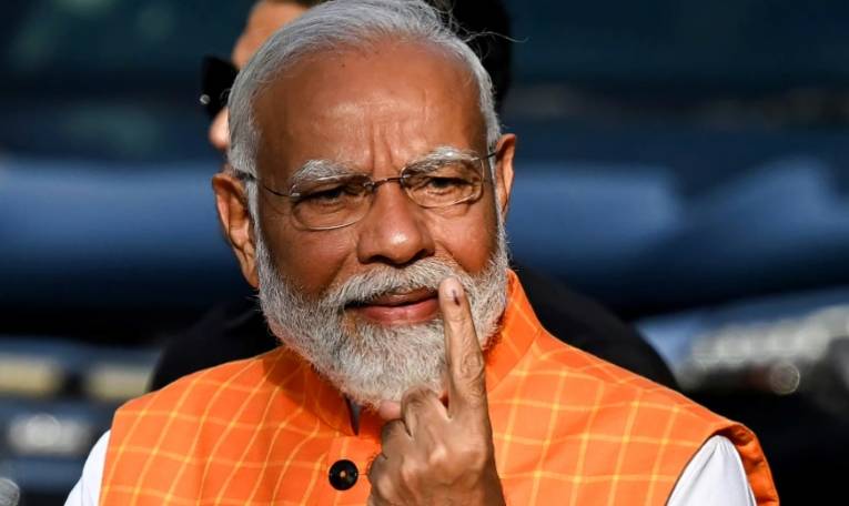 Le Premier ministre indien Narendra Modi montre son index taché d'encre après avoir voté aux élections générales, le 7 mai 2024 à Ahmedabad ( AFP / Sajjad HUSSAIN )
