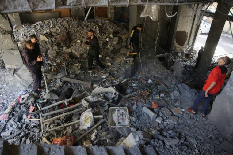 Des Palestiniens inspectent les dégâts dans la maison de la famille Al-Tabatibi après une frappe israélienne dans le quartier d'al-Daraj, à Gaza, le 12 avril 2024 ( AFP / - )