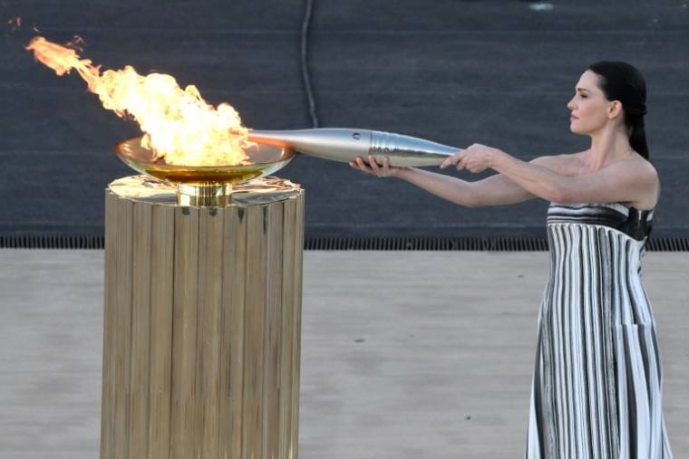 L'actrice grecque Mary Mina dans le rôle d'une grande prêtresse allume la flamme olympique lors de la cérémonie de remise aux orgnaisateurs des JO-2024 de Paris, le 26 avril 2024 à Athènes ( AFP / Angelos Tzortzinis )