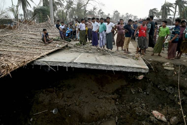 Des habitants sur un pont brisé par le cyclone Mocha, au camp de déplacés rohingyas de Khaung Dote Khar à Sittwe, le 15 mai 2023 ( AFP / Sai Aung MAIN )