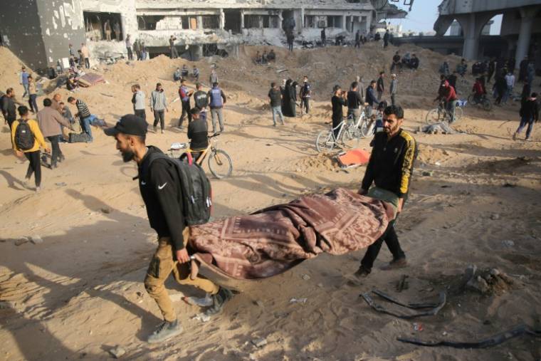 Des Palestiniens transportent un corps couvert dans le complexe hospitalier d'al-Chifa dévasté par une opération militaire israélienne, le 1er avril 2024 ( AFP / - )