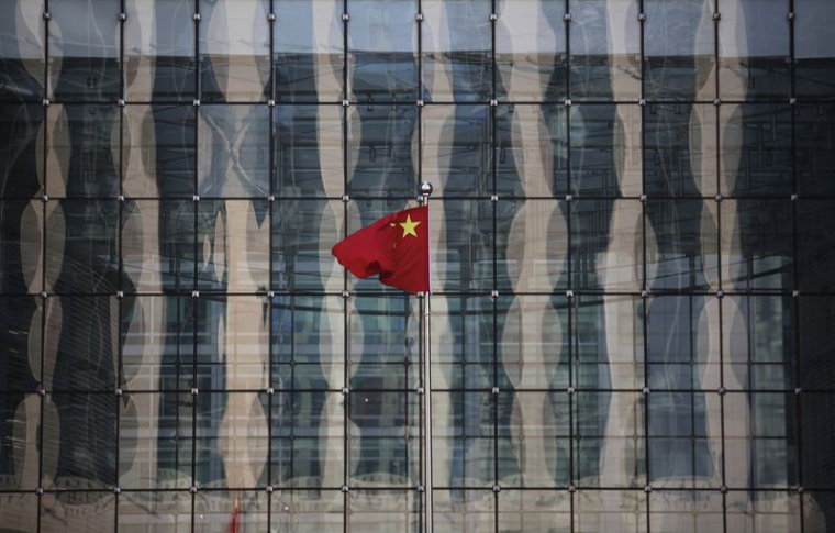 Un drapeau national chinois flotte au siège d'une banque commerciale dans une rue financière près du siège de la Banque populaire de Chine, la banque centrale chinoise, dans le centre de Pékin