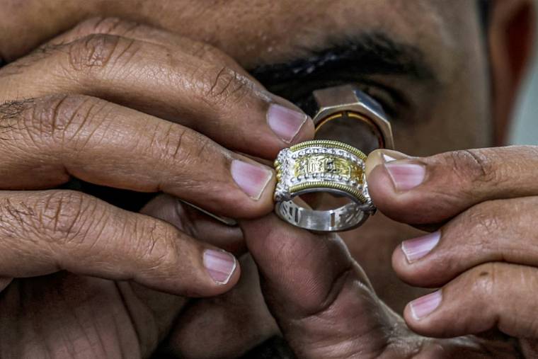 Un forgeron inspecte un bijou dans l'atelier d'Azza Fahmy, dans une zone industrielle au sud-ouest du Caire, le 19 février 2023 ( AFP / Khaled DESOUKI )