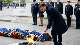 Le président Emmanuel Macron ravive la flamme du soldat inconnu sous l'Arc de Triomphe à Paris pour célébrer le 79e anniversaire de l'Armistice de 1945 ( POOL / Johanna Geron )