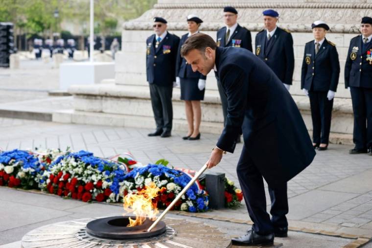 Le président Emmanuel Macron ravive la flamme du soldat inconnu sous l'Arc de Triomphe à Paris pour célébrer le 79e anniversaire de l'Armistice de 1945 ( POOL / Johanna Geron )