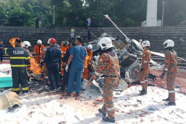 Photo diffusée le 23 avril 2024 par le service d'incendie et de secours de l'Etat de Perak montrant des sauveteurs sur le site d'une collision entre deux hélicoptères militaires à Lumut, en Malaisie ( Service d'incendie et de secours de l'Etat de Perak / Handout )