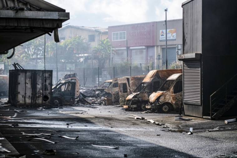 Des véhicules incendiés dans la zone industrielle Normandie de Nouméa, en Nouvelle-Calédonie, le 20 mai 2024 ( AFP / Theo Rouby )