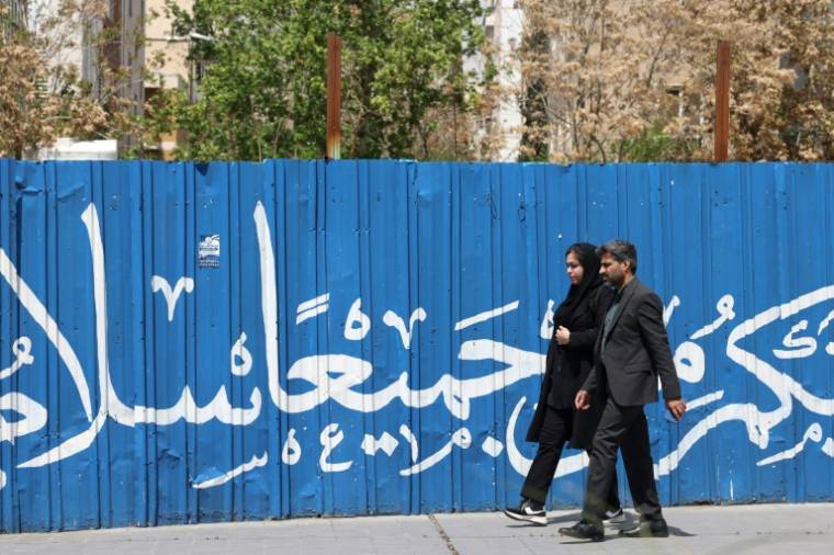 Des Iraniens marchent, le 13 avril 2024 à Téhéran  ( AFP / ATTA KENARE )