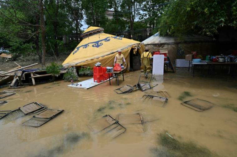 Des habitants nettoient et récupèrent des affaires après des inondations à Quingyuan, dans la province du Guangdong, le 24 avril 2024 dans le sud de la Chine ( AFP / HECTOR RETAMAL )