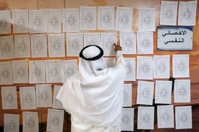 Un homme consulte une liste électorale le 4 avril 2024 dans un bureau de vote lors des élections législatives koweïtiennes dans la ville de Koweït ( AFP / YASSER AL-ZAYYAT )