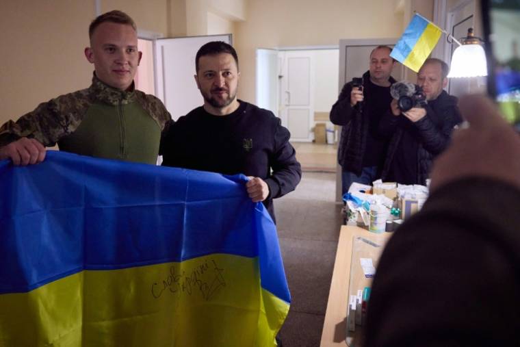 Photo fournie par la présidence ukrainienne montrant le président  Volodymyr Zelensky (C) poser avec un soldat lors d'une visite aux troupes dans la région de Donetsk, dans l'est de l'Ukraine, le 19 avril 2024 ( UKRAINIAN PRESIDENTIAL PRESS SERVICE / Handout )