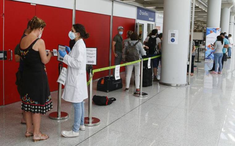 Des passagers font la queue devant un point de dépistage du coronavirus à l'aéroport de Son Sant Joan à Palma de Majorque