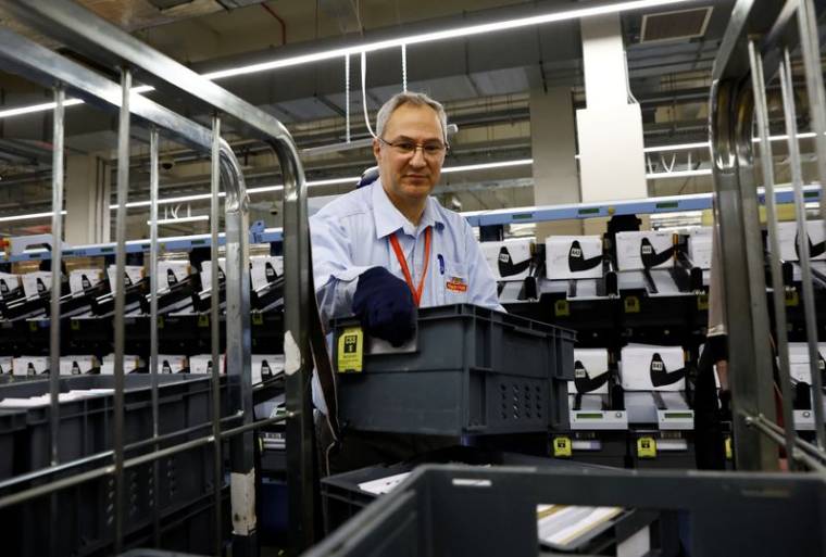 Un membre du personnel travaille sur la machine de tri intelligente au centre de courrier de Mount Pleasant à Londres