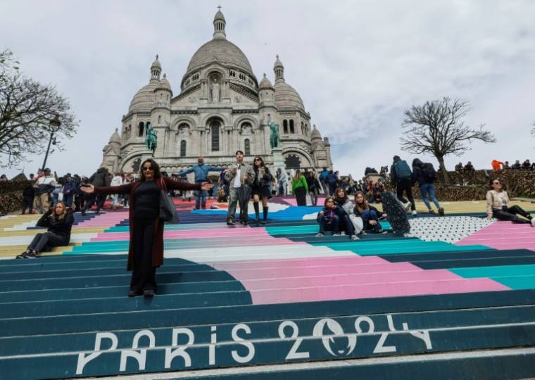 Des escaliers peints aux couleurs des prochains Jeux olympiques de Paris 2024, devant la basilique du Sacré-Cœur, au sommet de la butte Montmartre, le 17 avril 2024 à Paris ( AFP / Geoffroy VAN DER HASSELT )