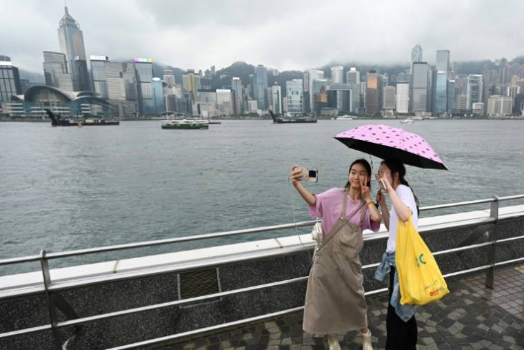 Des touristes de Chine continentale sur le front de mer de Tsim Sha Tsui à Hong Kong, le 1er mai 2024 ( AFP / Peter PARKS )