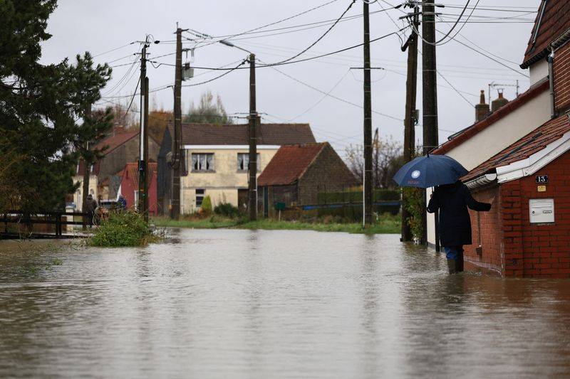 Une femme marche dans une rue inondée du Doulac, dans le nord de la France