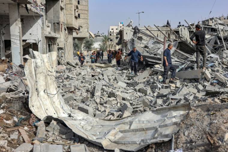 Des personnes marchent dans les décombres d'un bâtiment effondré à la suite d'un bombardement israélien dans la ville de Gaza, le 18 avril 2024,  ( AFP / - )