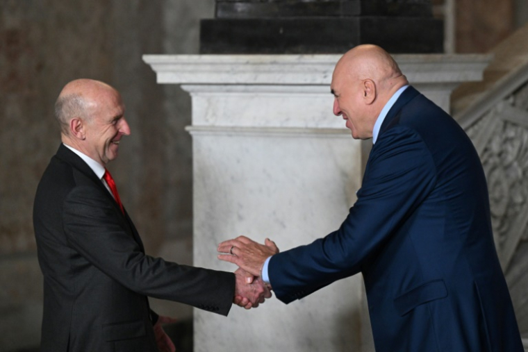 Le ministre italien de la Défense Guido Crosetto (D) et son homologue britannique John Healey se serrent la main durant la cérémonie d'accueil d'un G7 Défense à Naples le 19 octobre 2024 ( AFP / Tiziana FABI )