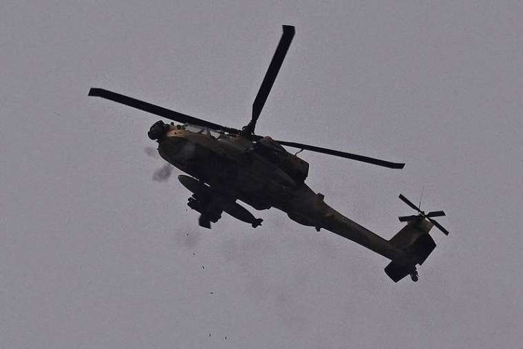 Un hélicoptère d'attaque AH-64 Apache de l'armée de l'air israélienne tire avec sa mitrailleuse, près de la frontière entre l'Israël et la bande de Gaza