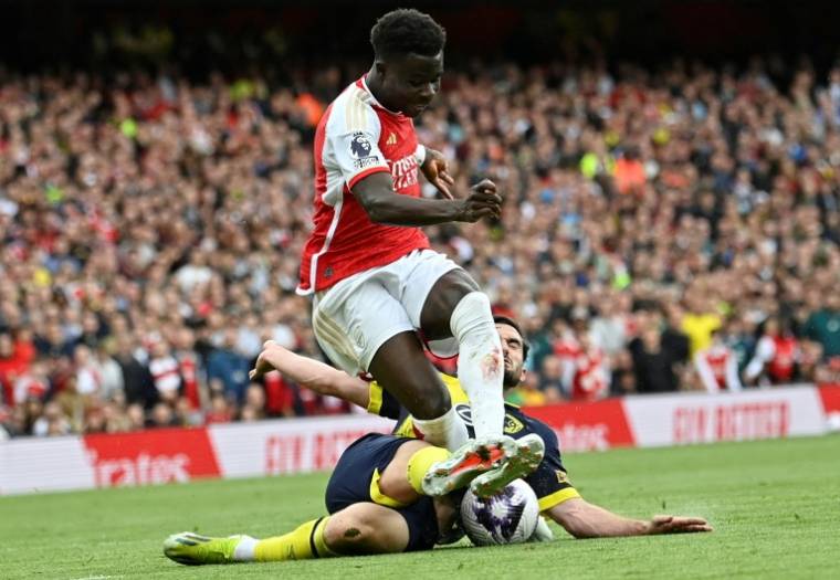Le milieu d'Arsenal Bukayo Saka échappe à un tacle samedi contre Bournemouth, et marquera dans ce  match de Premier League son 20e but de la saison, toutes compétitions confondues. ( AFP / JUSTIN TALLIS )