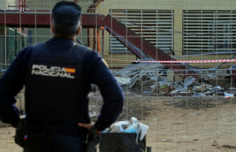 Un policier devant un collège de Massanassa, au sud de Valence, où un ouvrier qui travaillait à des réparations après les inondations du mois dernier a été tué par l'effondrement d'un toit, le 24 novembre 2024 en Espagne ( AFP / JOSE JORDAN )