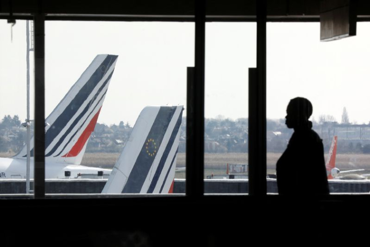 Un passager dans l'aéroport d'Orly devant des avions d'Air France