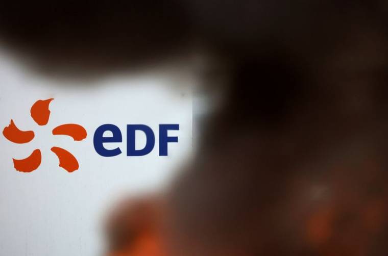 Le logo de l'entreprise d'EDF derrière un feu allumé lors d'une grève