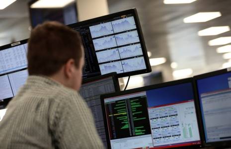 Des traders travaillent en salle des marchés de l'indice IG, à Londres