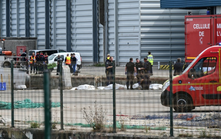 Des pompiers sont rassemblés autour des dépouilles de migrants morts dans le naufrage de leur embarcation, lors d'une tentative de traversée de la Manche le 3 septembre 2024 ( AFP / BERNARD BARRON )