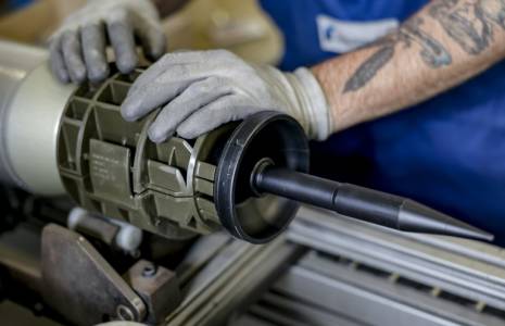 Un technicien de la société d'armement allemande Rheinmetall travaille sur des munitions de 120 mm pour les chars de combat Leopard qui seront livrés aux forces ukrainiennes, à l'installation de Rheinmetall à Unterluess, dans le nord de l'Allemagne, le 6 juin 2023. ( AFP / Axel Heimken )