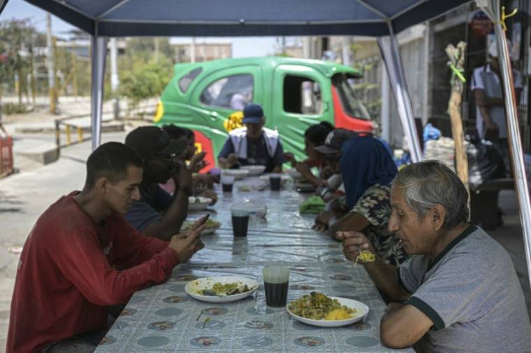 Des personnes déjeunent dans un restaurant local qui propose des plats à base d'épluchures, de tiges et d'autres parties de légumes habituellement jetés, dans la banlieue de Lima, le 5 avril 2024 ( AFP / Ernesto BENAVIDES )