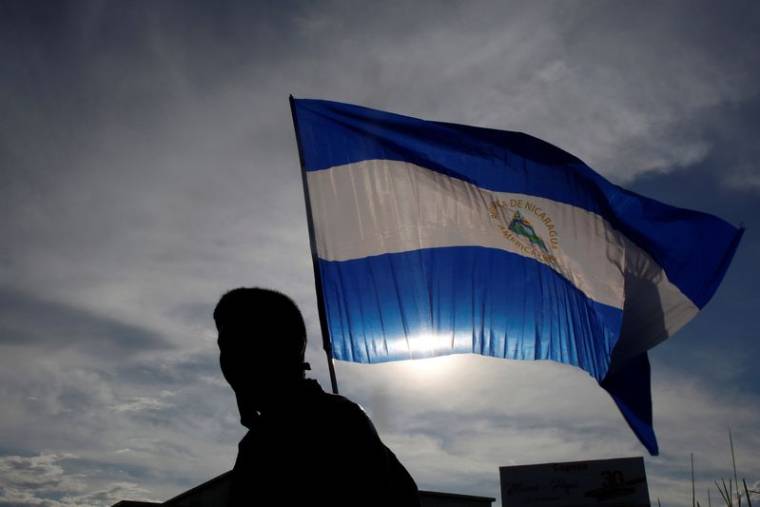 Une personne brandit un drapeau national nicaraguayen lors d'une manifestation à Managua
